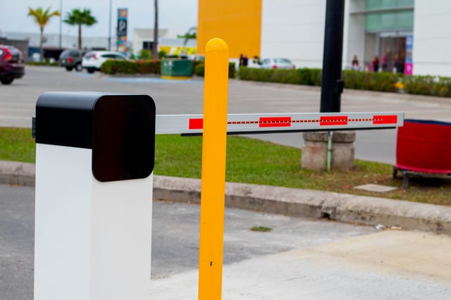 Barrera vehicular automatizada con luces LED en el brazo para control de acceso a estacionamientos corporativos y comerciales, representando soluciones de seguridad perimetral de Vorak.