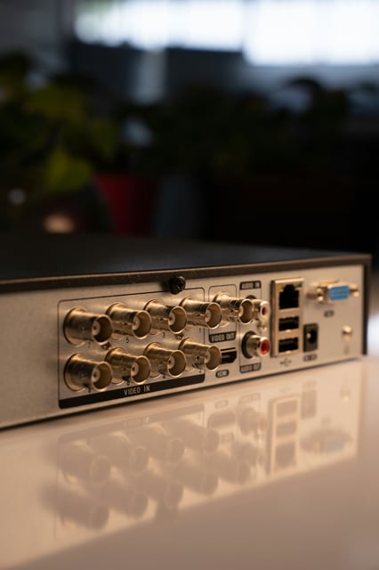Grabador digital DVR de 8 canales para sistemas de CCTV, mostrando los puertos de conexión para cámaras de seguridad, audio y red en un servicio de instalación profesional.