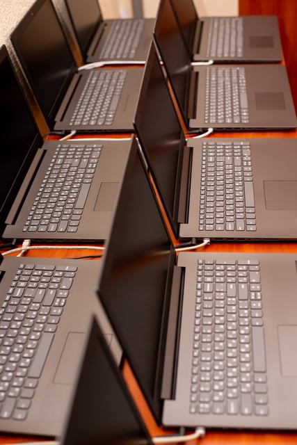 Lote de computadoras portátiles remanufacturadas en proceso de revisión exhaustiva y configuración técnica para garantizar su perfecto funcionamiento a bajo costo.